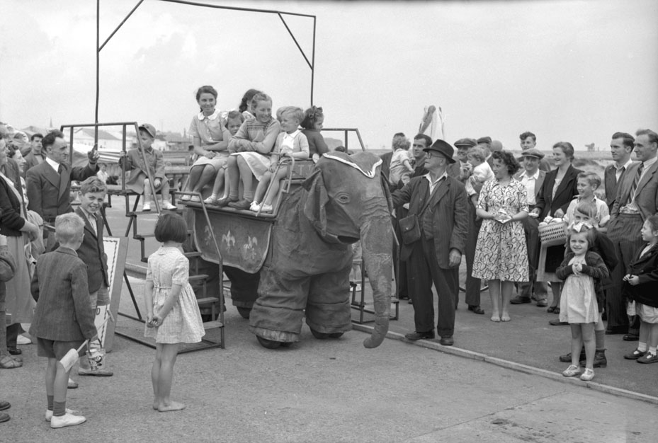  Black and white photograph of children sitting on a mechanical elephant